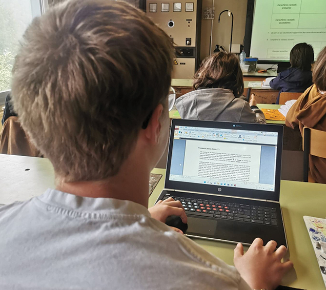 Le jeune apprend à l'école avec un ordinateur