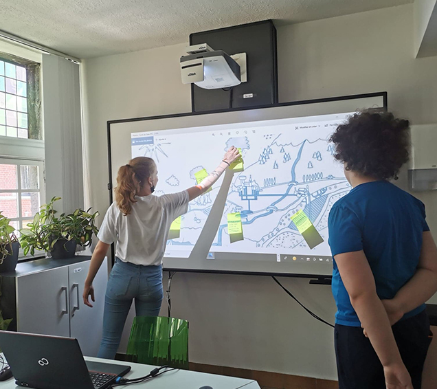 Deux jeunes utilisent un tableau interactif pour apprendre le cycle de l'eau