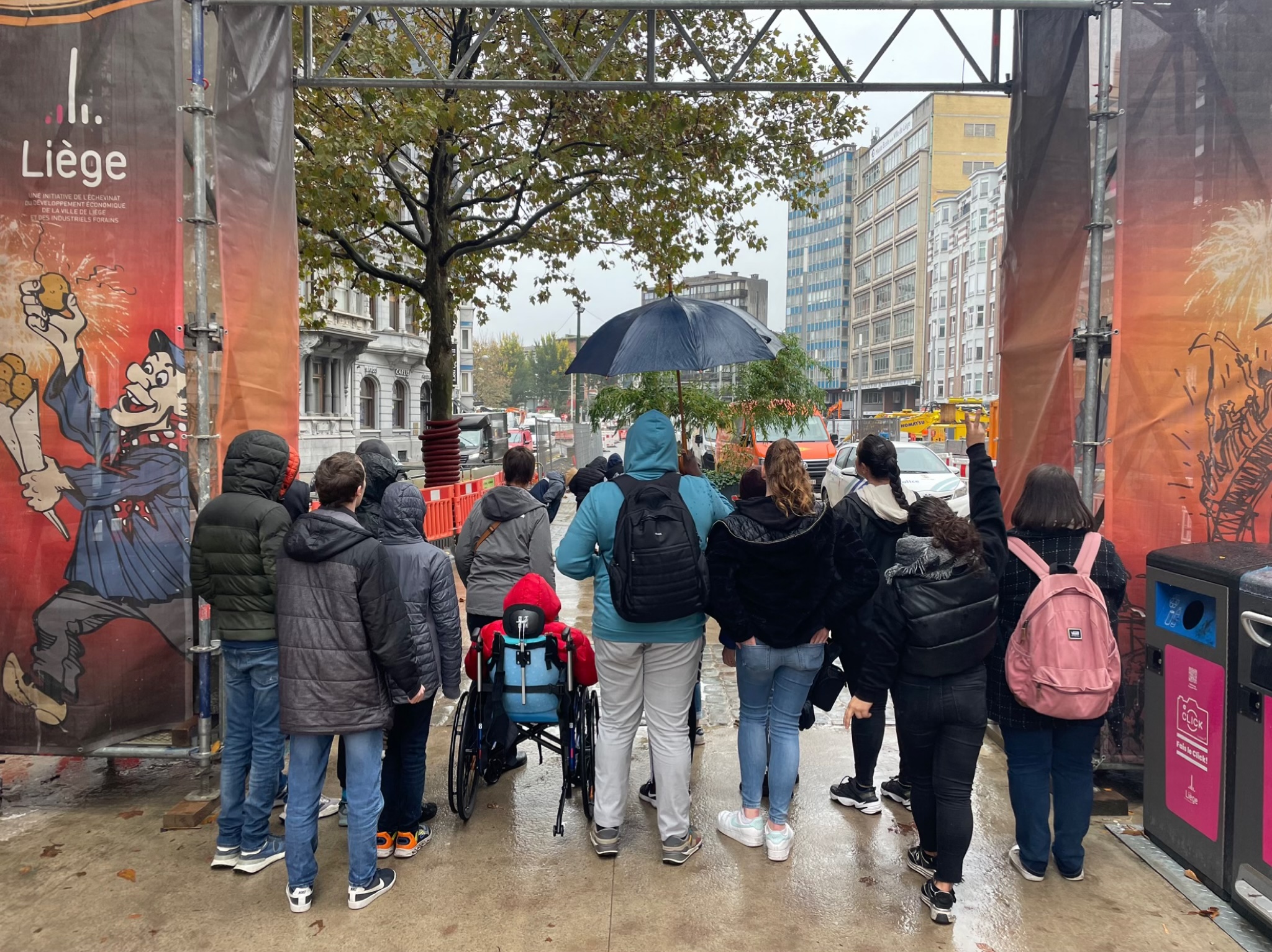Les jeunes et les référentes encadrant la sortie à la foire posent devant l'arche de l'entrée. 