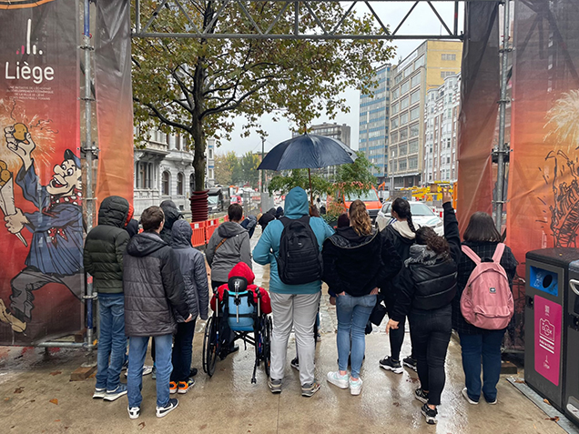 Les jeunes et les référentes encadrant la sortie à la foire posent devant l'arche de l'entrée. 